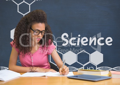 Student girl at table reading against blue blackboard with science text and graphics