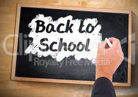 Hand writing back to school on blackboard