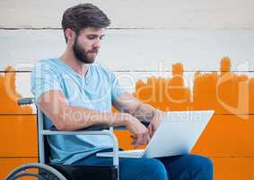 Disabled man in wheelchair with bright painted orange background