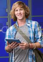 male student holding tablet in front of lockers