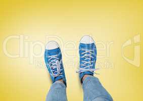 Blue shoes on feet with yellow background