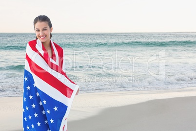 Happy woman holding a USA flag in the beach