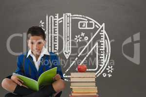 Student boy sitting on a table reading against grey blackboard with school and education graphic