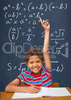 Happy student boy at table raising hand against blue blackboard with education and school graphics
