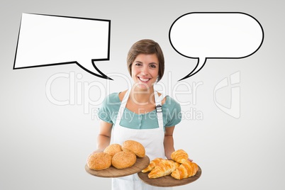 Happy small business owner woman with speech bubbles holding pastries against grey background