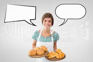 Happy small business owner woman with speech bubbles holding pastries against grey background