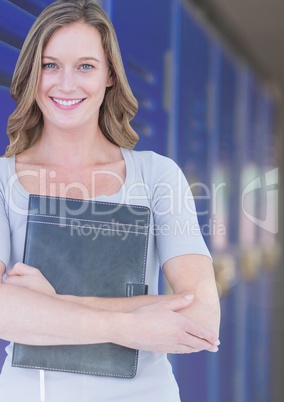 female student holding book in front of lockers