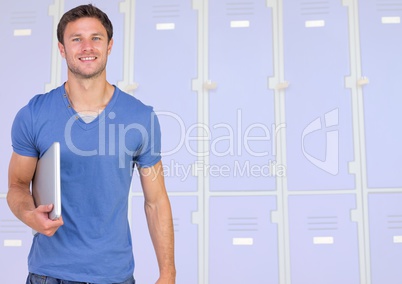 male student holding book in front of lockers