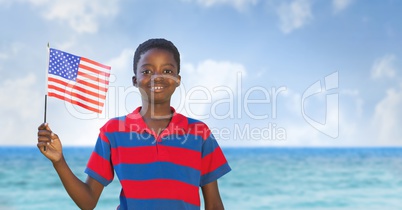 Happy boy holding a USA flag in the beach