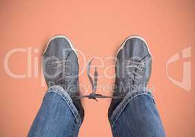 Grey shoes on feet with pink background