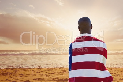 Man holding a USA flag in the beach