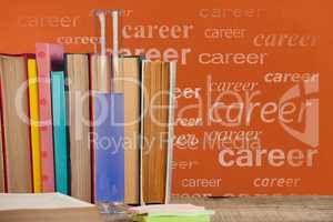 Books on the table against orange blackboard with career text