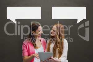 Business women with speech bubbles holding a tablet against grey background