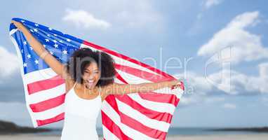 Happy woman holding a USA flag in the beach
