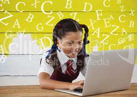 Many letters around Schoolgirl on laptop with yellow painted background