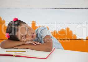 Schoolgirl asleep at desk with painted orange background