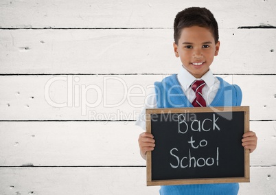 Schoolboy holding blackboard with Back to school text