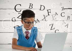 Many letters around Schoolboy on laptop with wood background