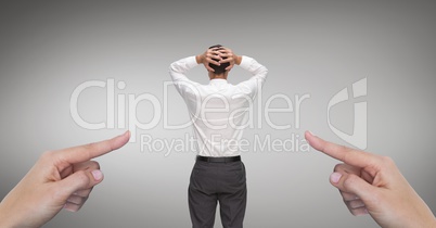 Hands pointing at surprised business man against grey background