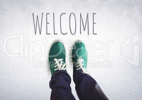 Welcome text and green shoes on feet with grey background