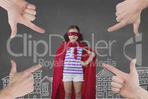 Hands pointing at girl in a super heroine custom against grey background with city illustration