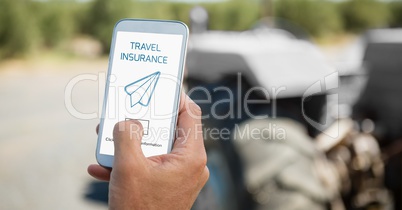 Person holding a phone with travel insurance concept on screen