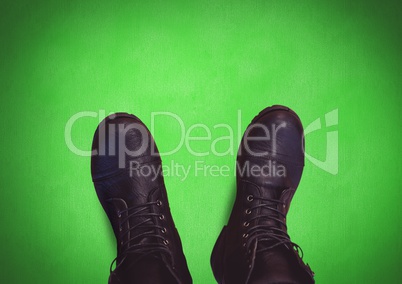 Black shoes on feet with green background