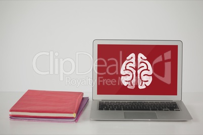 Computer on a school table with brain icon on screen