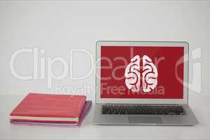 Computer on a school table with brain icon on screen