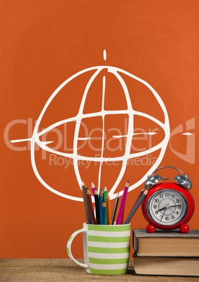 Books on the table against orange blackboard with education and school graphics