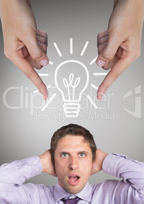 Hands pointing at surprised business man against grey background bulb icon