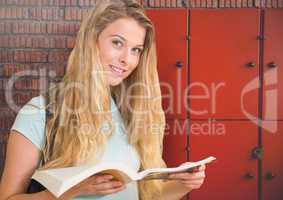 female student holding book in front of lockers