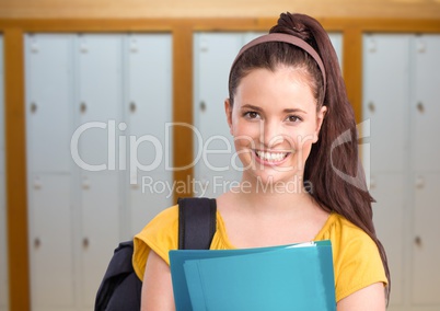 female student holding folder in front of lockers