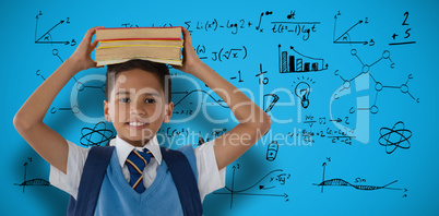 Composite image of smiling schoolboy carrying books on head over white background