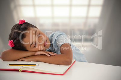 Composite image of girl napping on book at desk