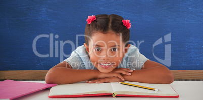 Composite image of girl clenching teeth while leaning on book