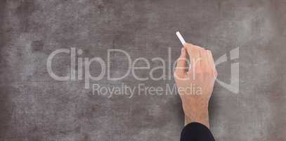 Composite image of hand of a businessman writing with a white chalk