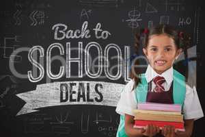 Composite image of smiling schoolgirl carrying books