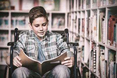 Disabled schoolboy reading book in library