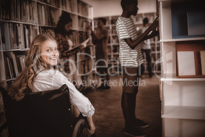 Disabled girl on wheelchair in library