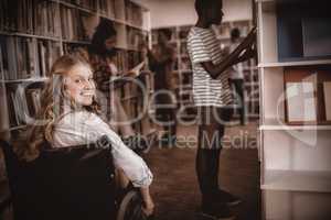 Disabled girl on wheelchair in library