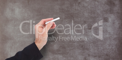 Composite image of hand holding a chalk and writing something