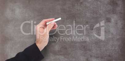 Composite image of hand holding a chalk and writing something