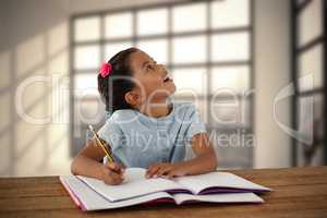 Composite image of girl looking up while writing in book