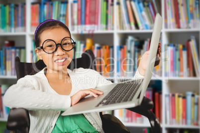 Composite image of young girl showing laptop while sitting on wheelchair