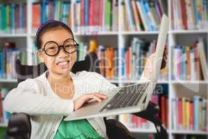 Composite image of young girl showing laptop while sitting on wheelchair
