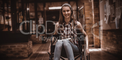 Disabled schoolgirl on wheelchair in corridor at school