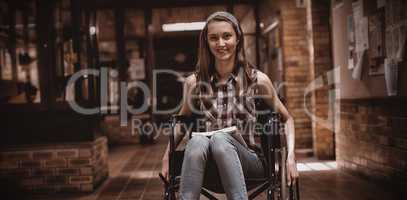 Disabled schoolgirl on wheelchair in corridor at school