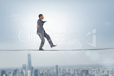 Composite image of businessman performing a balancing act