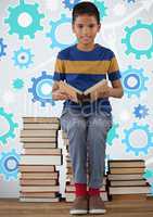 Boy reading and sitting on book tower in front of cog gear settings